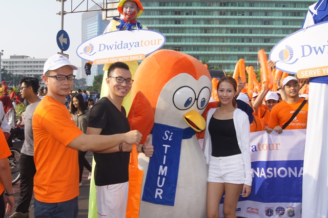 Hendri Yapto, VP Commercial Dwidayatour, memberikan hadiah kejutan kepada pelanggan dalam Parade Simpatik Hari Pelanggan Nasional