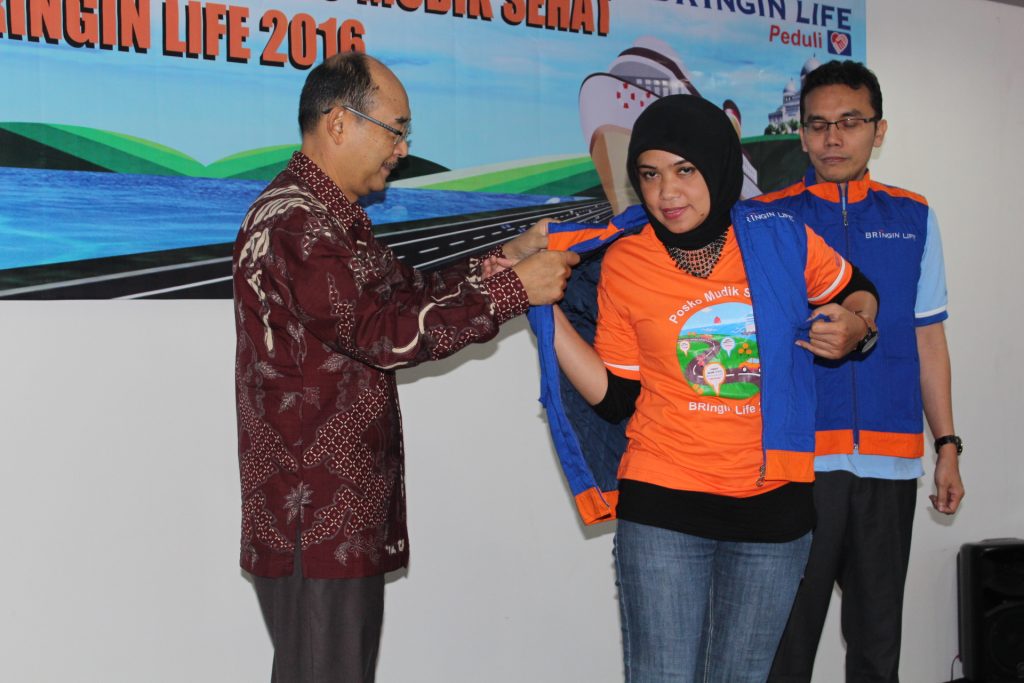 Direktur Utama BRIngin Life, Nandi H. Hamaki membantu memakaikan rompi kepada salah seorang petugas Posko Mudik Sehat dan Arus Balik BRIngin Life di Jakarta, 28 Juni 2016. Ist